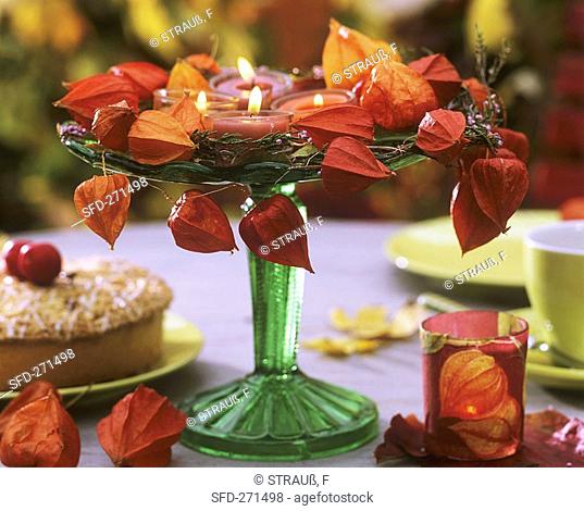 Glass stand with autumn decorations and tea lights