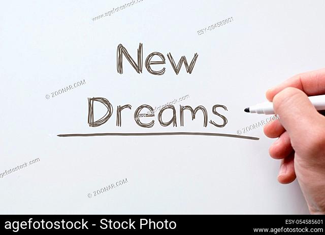 Human hand writing new dreams on whiteboard