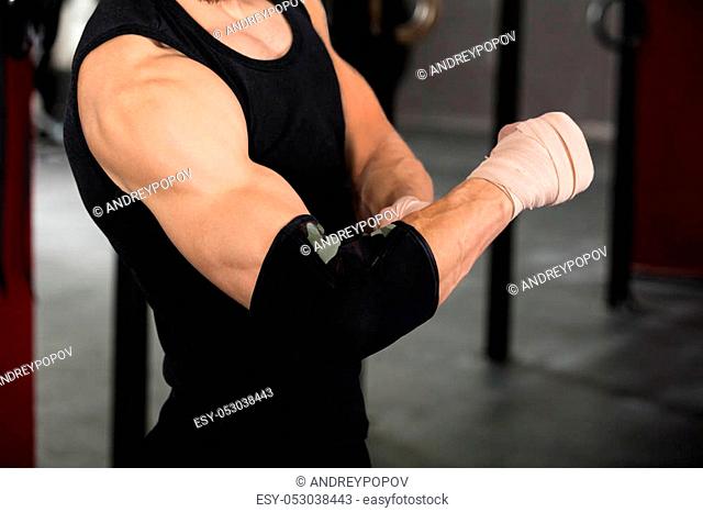Close-up Of An Athlete Person Wearing Bandage On Elbow In The Gym