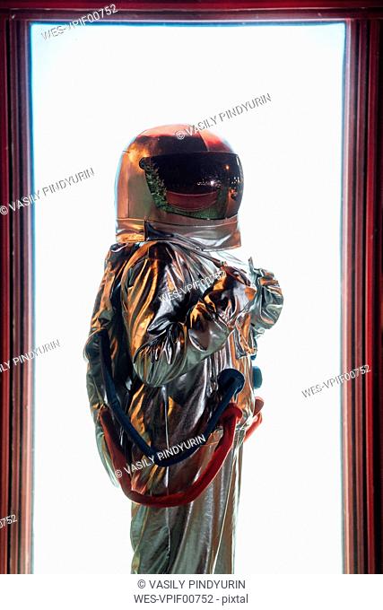 Spaceman standing at an illuminated box