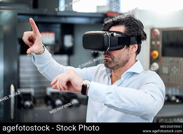 Businessman using VR glasses in a factory