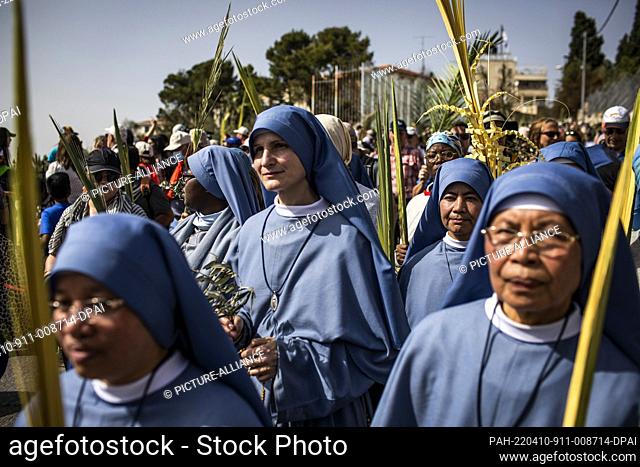 10 April 2022, Israel, Jerusalem: Nuns hold palm fronds as they take part in the Palm Sunday procession in Jerusalem. Palm Sunday commemorates the entry of...