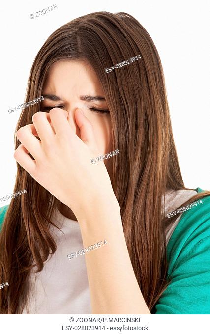 Young beautiful woman with sinus pressure, touching her nose