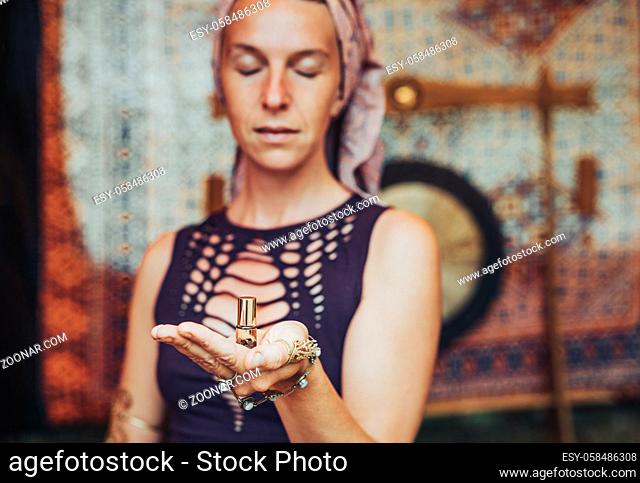 beautiful woman with essential perfume in her hand