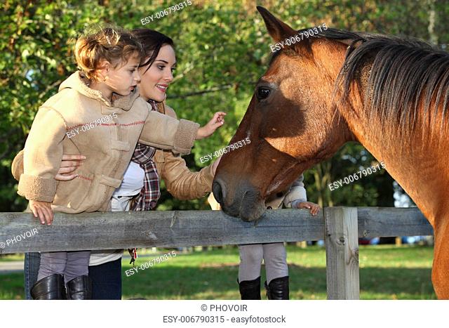 Mother and daughter next to horse