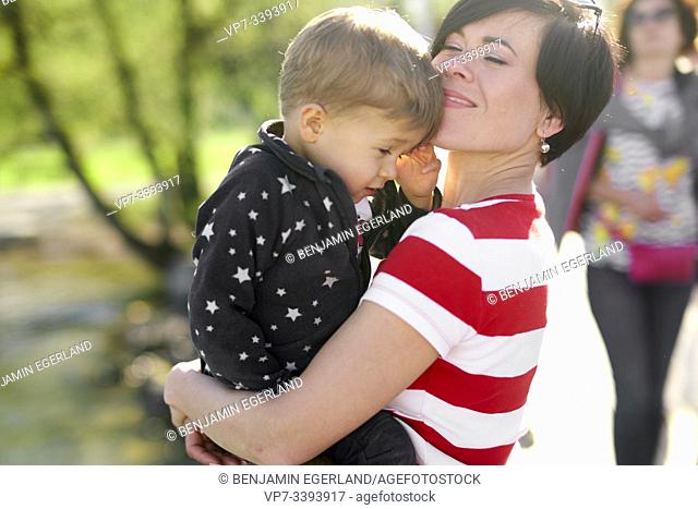 happy woman enjoying togetherness with son, toddler child, outdoors in park