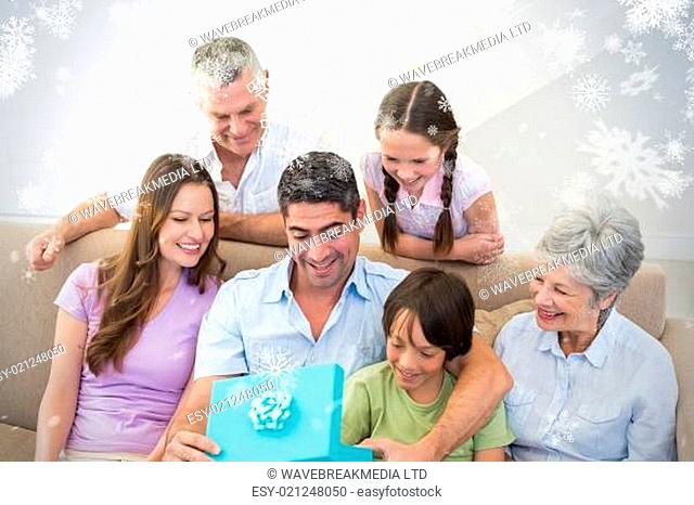 Composite image of man opening birthday present at home