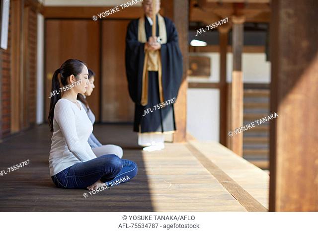 Japanese priest preaching to women at a temple