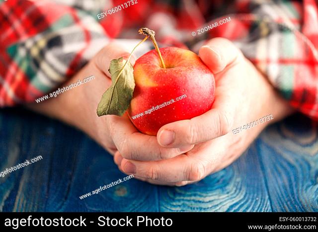 Man in plaid hold one apple