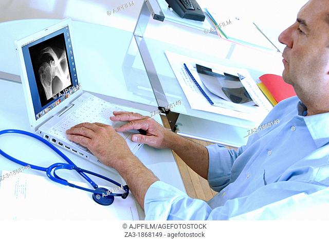 X-ray diagnosis  Doctor typing up the results of a patient's shoulder X-ray