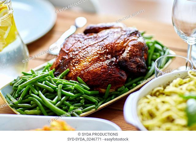 roast chicken with garnish of green peas on table
