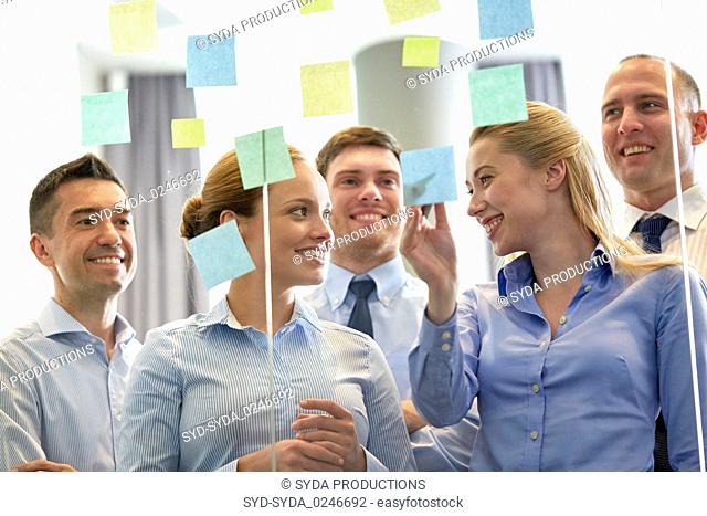 business team at glass wall with sticky notes