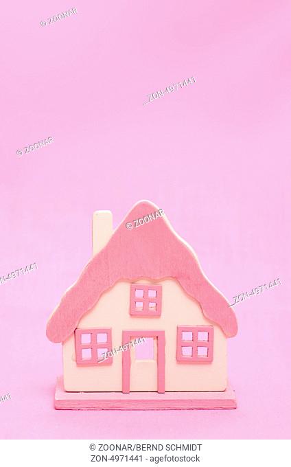 Rosa Haus vor pink Hintergrund mit Textfreiraum für Werbung