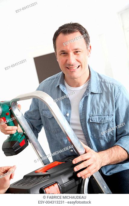 Closeup of smiling man with electric drill