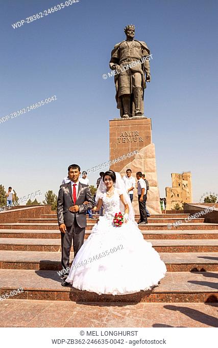 Bride and groom in front of Statue of Amir Timur, also known as Temur and Tamerlane, Shakhrisabz, Uzbekistan