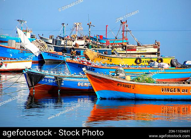 Colorful fishing boats anchored in Paracas Bay, Peru. Paracas is a small port town catering to tourists visiting Paracas Reserve and Ballestas islands