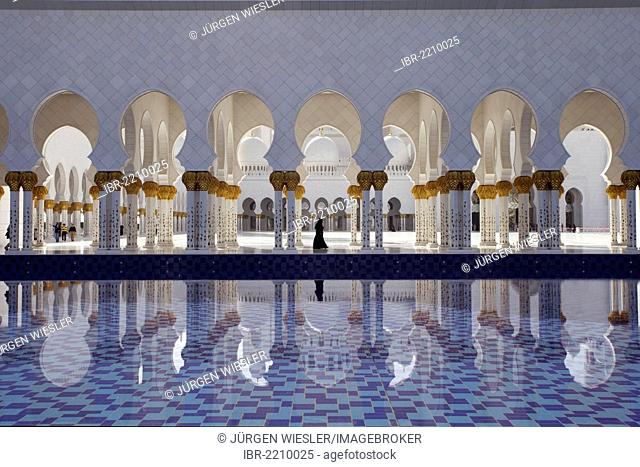 Colonnade reflected in a pool of water in the Sheikh Zayed Mosque in Abu Dhabi, United Arab Emirates, Middle East, Asia