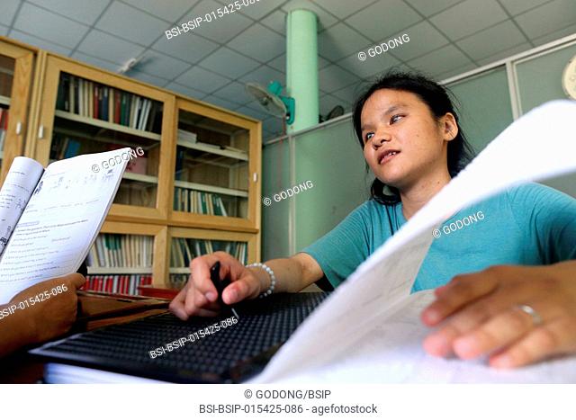 Vietnam. Center for blind children. Girl writing braille