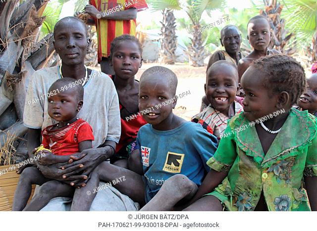 Internally displaced Nyakume Wuor Gai sits together with her own children and neighbour's children in front of a shed on an island near Nyal at the federal...