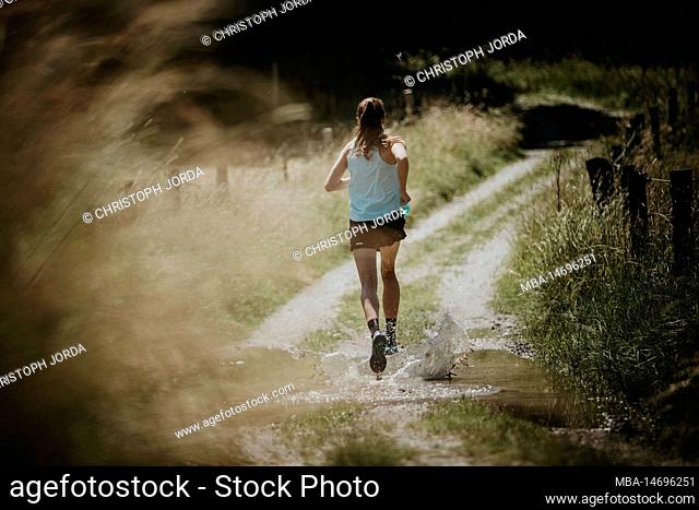 Professional triathlete on a trail running training lap in the forest near Kaufbeuren, Allgäu, Bavaria, Germany
