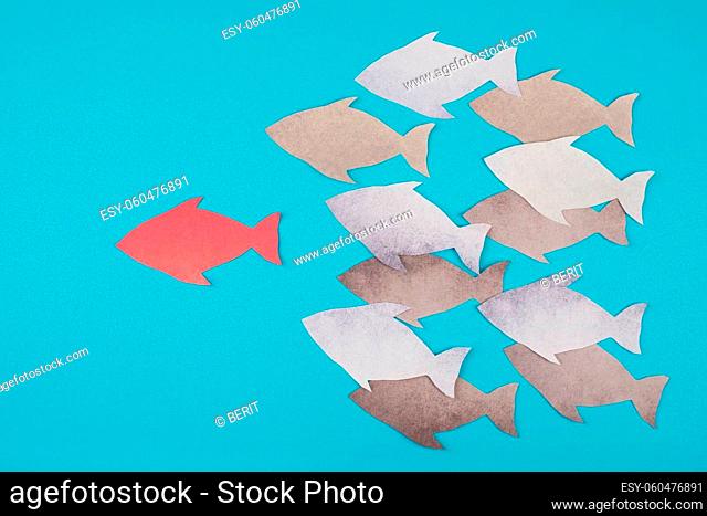 Red fish is the leader of the group, paper cut, blue colored background