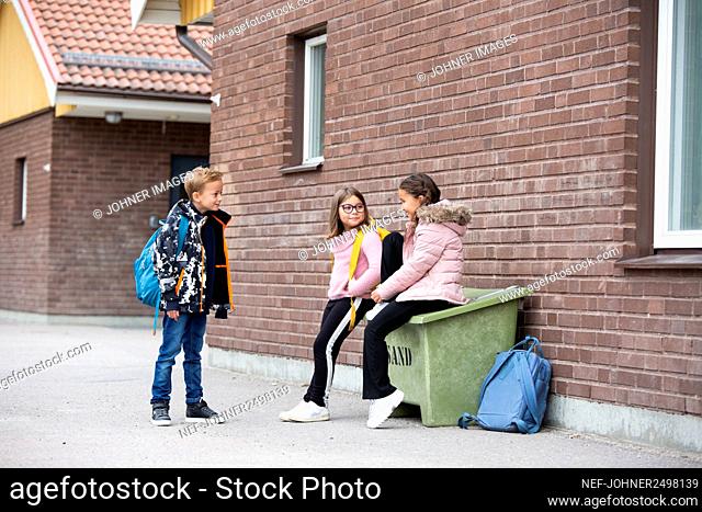Smiling children in front of school