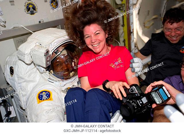 NASA astronauts Cady Coleman, Expedition 26 flight engineer, Alvin Drew and Michael Barratt (background), both STS-133 mission specialists