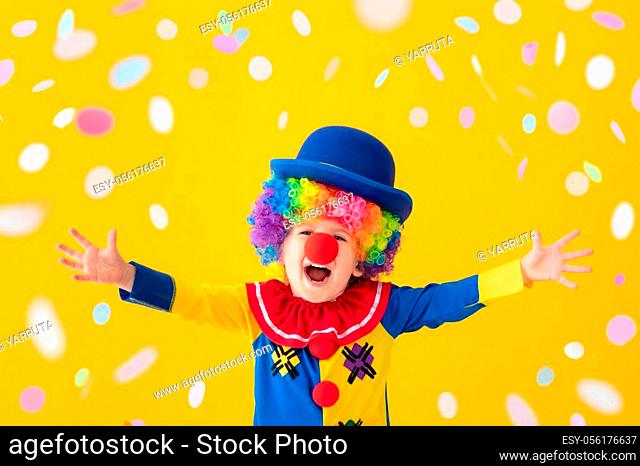 Funny kid clown against yellow background. Happy child playing indoor. 1 April Fool's day concept