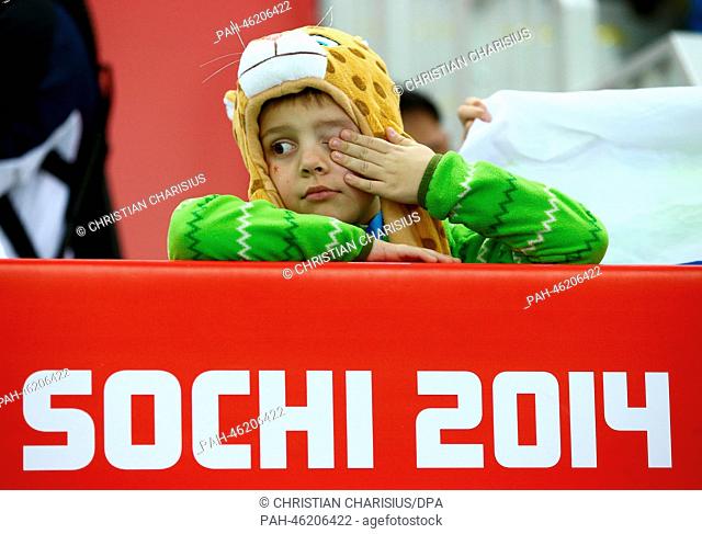 A young child wipes their eye during Men's 500 m in Adler Arena at the Sochi 2014 Olympic Games, Sochi, Russia, 10 February 2014