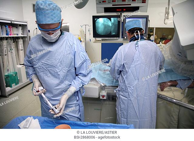 ARTERIAL ANGIOPLASTY EXAMINATION<BR>Photo essay from La Louvière clinic, France (59). Angioplasty.<BR>Preparation of the manometer for the inflation the...
