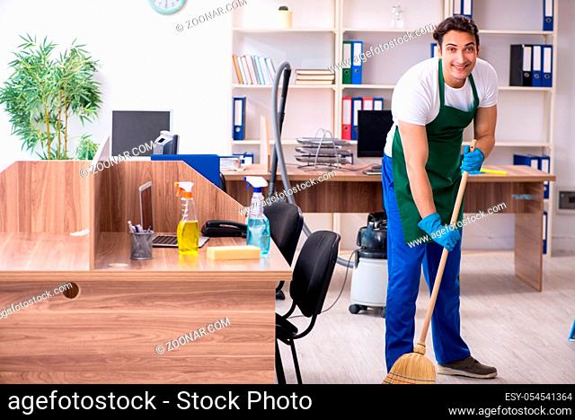 The young handsome contractor cleaning the office