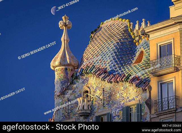 ENG: Sunrise over the roof of the Casa Batlló with the waning moon behind the cross of Saint George that crowns the façade (Barcelona, Catalonia, Spain)