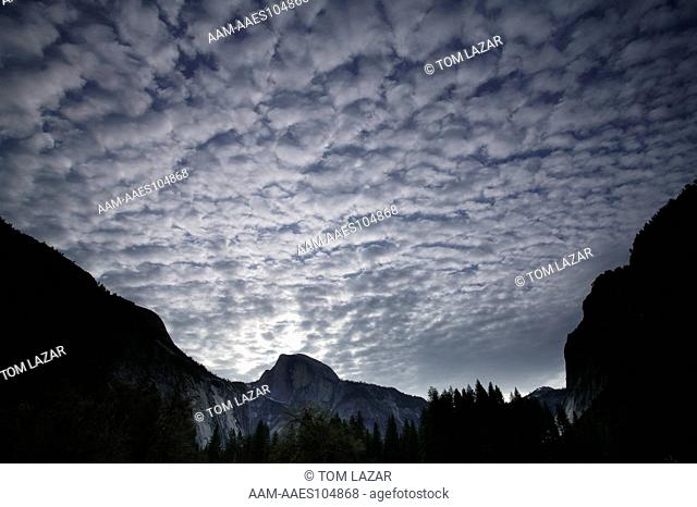 Yosemite National Park, California; Sierra Nevada Mountains; Cirrocumulus clouds in blue sky above Half Dome; early spring