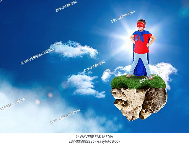 Young superhero boy on floating rock platform in sky