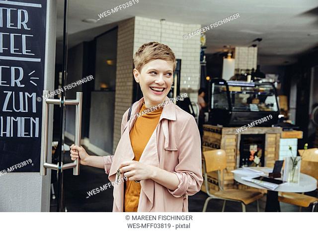 Female cafe owner unlocking the door in the morning
