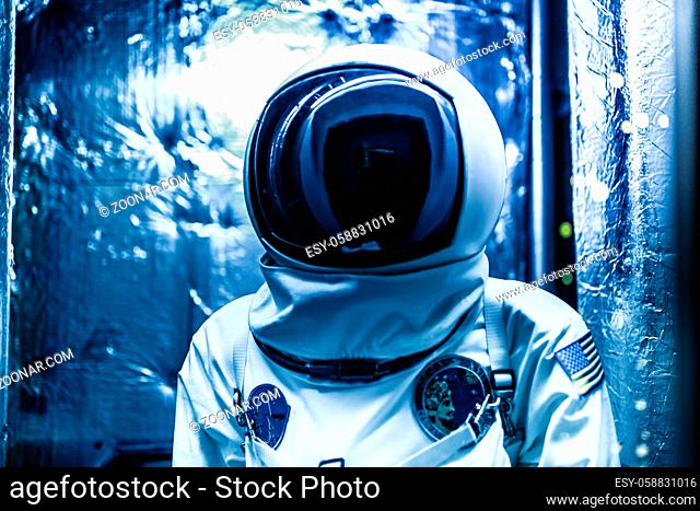 Cosmonaut in a space suit inside space ship
