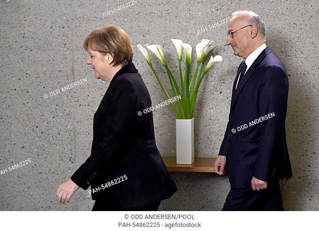 German chancellor Angela Merkel (L) leaves after signing the condolences book next to French Ambassador Philippe Etienne on January 8
