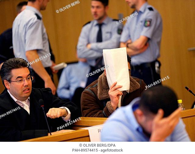 Two defendants (front, 2nd row R) sit between lawyers in a courtroom in Aachen, Germany, 03 April 2017. Eight men are accused of attacking soccer players over...