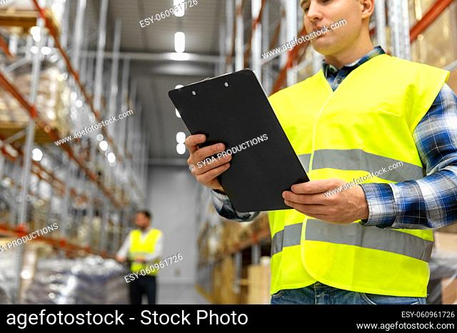 warehouse worker with clipboard in safety vest