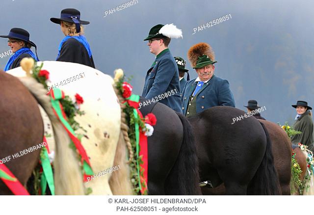 Women and men in traditional costume sit on festively decorated horses near Schwangau, Germany, 11 October 2015. They are taking part in the feast of St