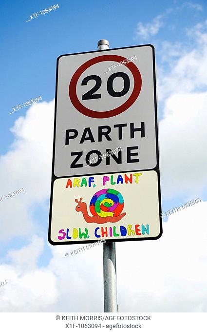 20 miles per hour zone bilingual language sign, with hand painted 'slow children' snail picture in welsh and english, Wales UK