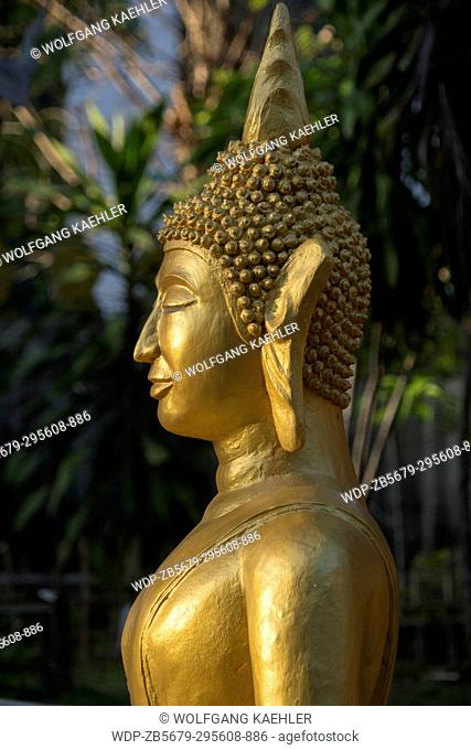 Detail of a guilded Buddha statue at Wat Xieng Muan (Xieng Muan Vajiramangalaram) a Buddhist temple in the UNESCO world heritage town of Luang Prabang in...