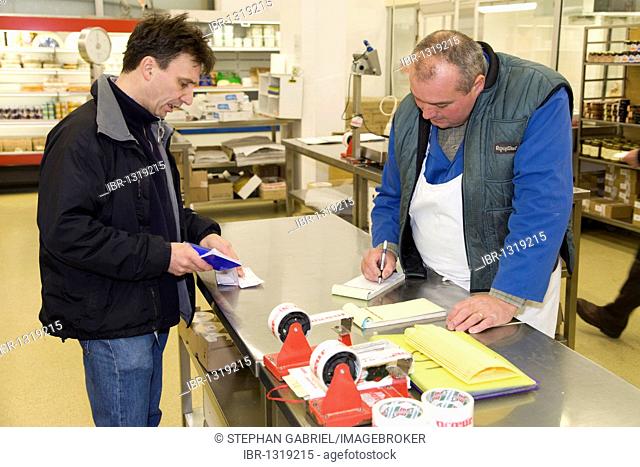 Francois Pasteau, chef from the L'Epi Dupin restaurant, with a salesman in the cheese hall, Pavillon des Fromages, Rungis wholesale market near Paris, France