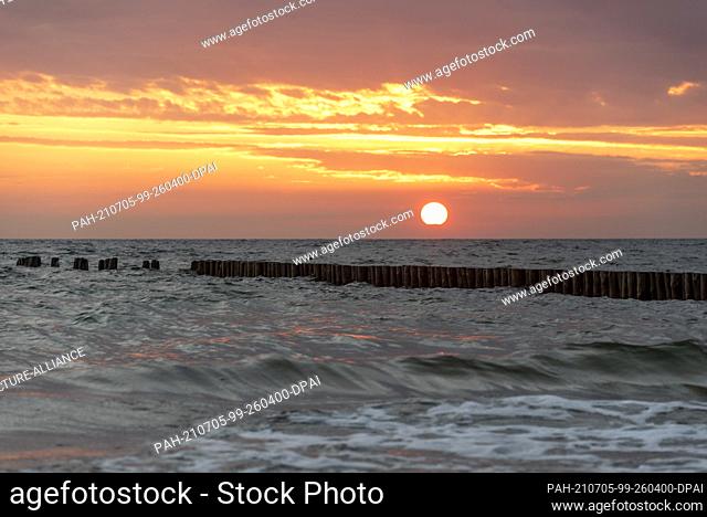 26 June 2021, Mecklenburg-Western Pomerania, Hiddensee: The sun sets on the beach of Hiddensee. Locals also affectionately call their island ""Dat söte...