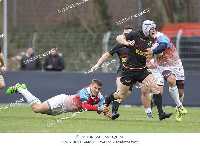 18 March 2018, Germany, Cologne: Rugby, Rugby Europe Championship, Germany vs Russia. Valery Dorofeev (Russia, 9) clings to Christopher Korn (Germany, 13)