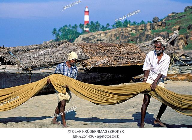 Fishermen pulling in their nets, lighthouse, Kovalam, Kerala, South India, India, Asia