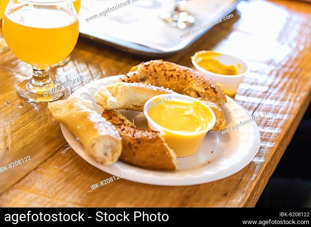 Abstract of small glass of micro brew beers and warm pretzels on bar