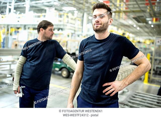 Two confident colleagues having a break in a modern factory