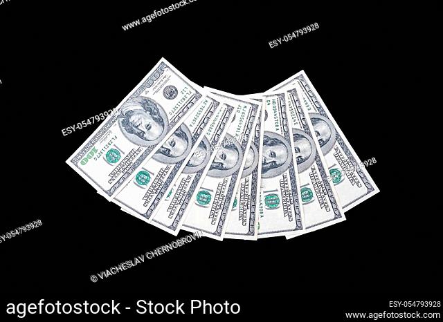 100 US dollar bills with a portrait of American President Benjamin Franklin folded in a semicircle on an isolated black background