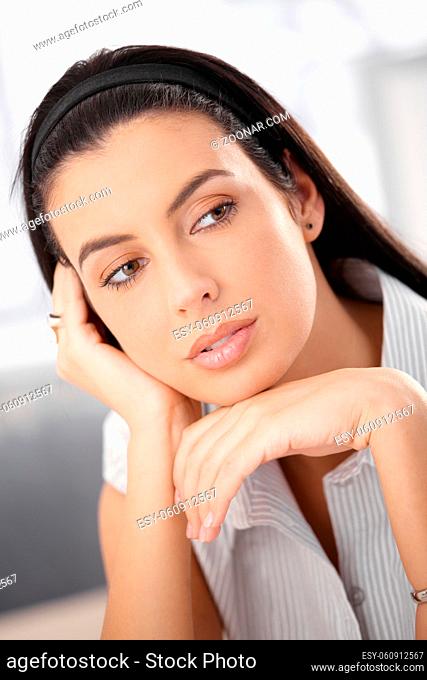 Closeup portrait of attractive woman with dark hair daydreaming